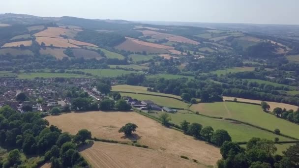 緑豊かな田舎に囲まれたイギリスの町へ飛んでいく — ストック動画