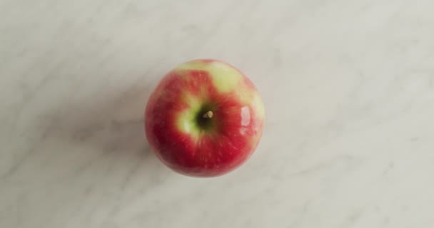 Ένα Μήλο Τοποθετείται Ένα Λευκό Μαρμάρινο Τραπέζι Ένα Κάτω Πλάνο — Αρχείο Βίντεο