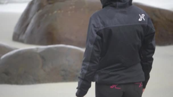 Kışlık Montlu Dar Pantolonlu Bir Kadın Kumsaldaki Kayaların Arasındaki Kaba — Stok video