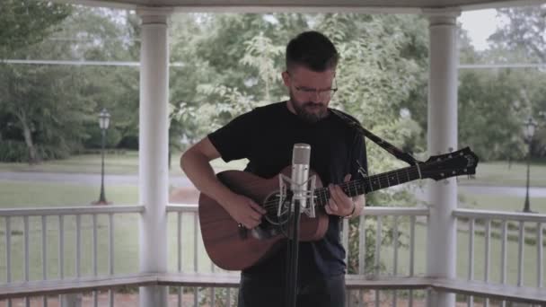 Homem Tocando Guitarra Cantando Sob Gazebo Chuva Slo Empurrar Tiro — Vídeo de Stock