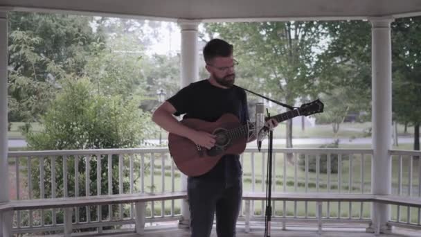 Hombre Tocando Guitarra Cantando Bajo Cenador Bajo Lluvia Amplia Rotación — Vídeos de Stock