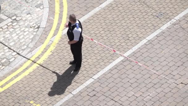 英国8月2018 犯罪現場のコルドン警察テープを持ち上げている警察官の空中で 一般の2人のメンバーが下を通過することを可能にする — ストック動画
