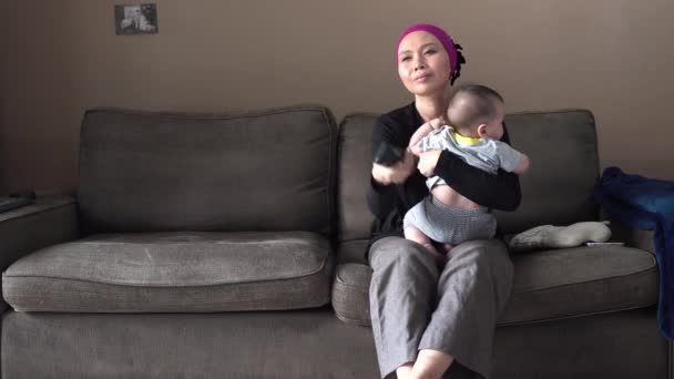 Junge Springt Mit Mutter Und Baby Auf Sofa Fernzusehen — Stockvideo