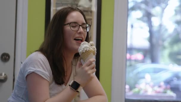 女孩一边吃冰淇淋一边笑 — 图库视频影像