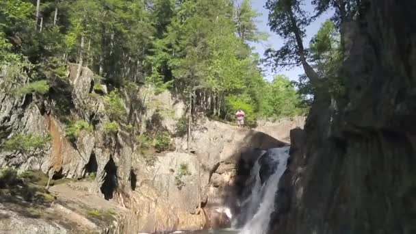 在缅因州的小瀑布旁 一名男性徒步旅行者慢吞吞地站在瀑布旁 — 图库视频影像