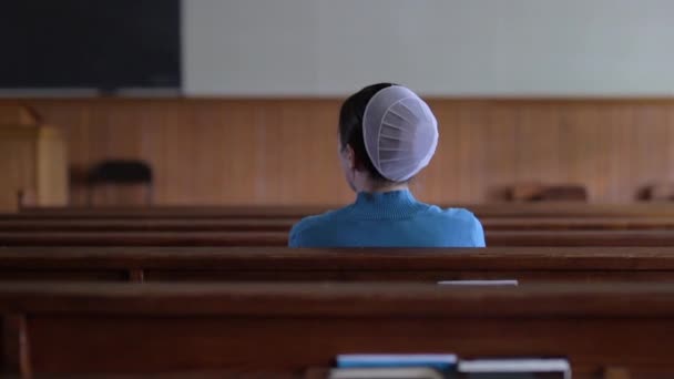 Μια Νεαρή Mennonite Γυναίκα Κάθεται Στα Στασίδια Μιας Άδειας Εκκλησίας — Αρχείο Βίντεο