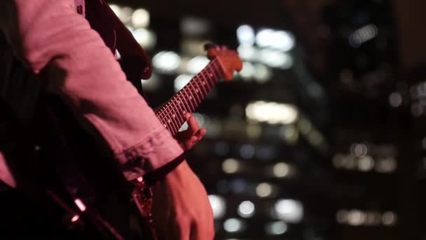 Ein Gitarrist Spielt Ein Solo Mit Der Stadt Hintergrund — Stockvideo