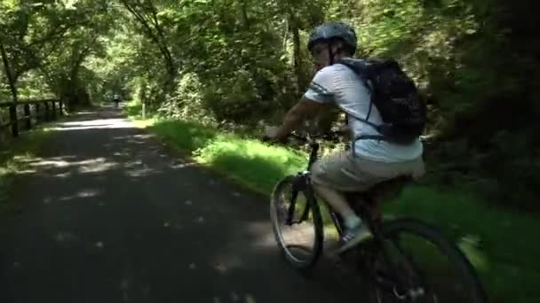 紧跟在一个骑自行车的少年后面 他从一个骑着另一辆自行车的老太婆身边经过 — 图库视频影像
