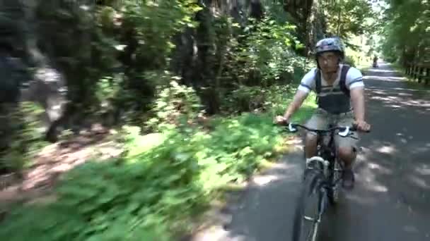 少年骑自行车在森林里铺好的小径上的闭塞 — 图库视频影像