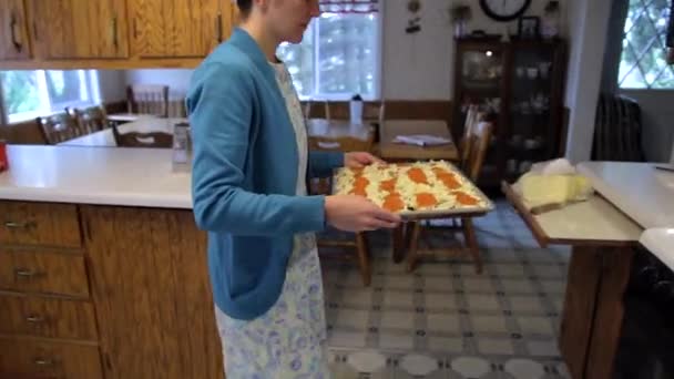 Una Mujer Menonita Sonríe Mientras Pone Una Pizza Casera Horno — Vídeos de Stock