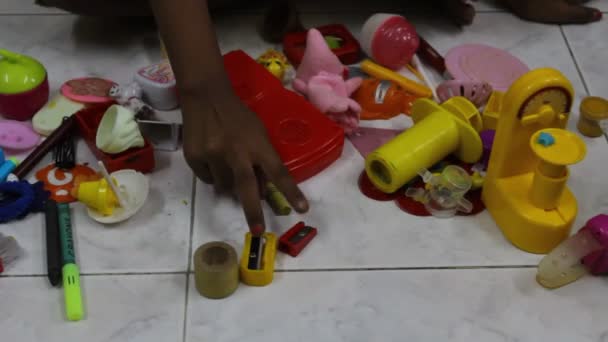 低光未編集のビデオの若い女の子見ますとともにカラフルなおもちゃの束を含む医師セットのおもちゃ — ストック動画