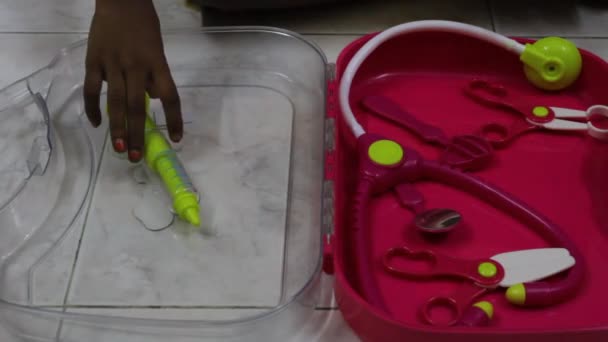 未经编辑的低光镜头 看到小女孩在玩一堆五颜六色的玩具 包括一套医生用的玩具 — 图库视频影像