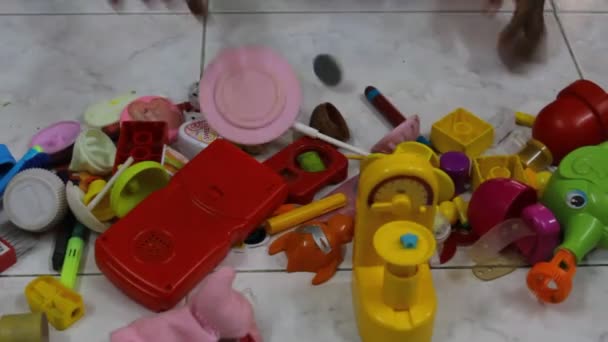 低光未編集のビデオの若い女の子見ますとともにカラフルなおもちゃの束を含む医師セットのおもちゃ — ストック動画
