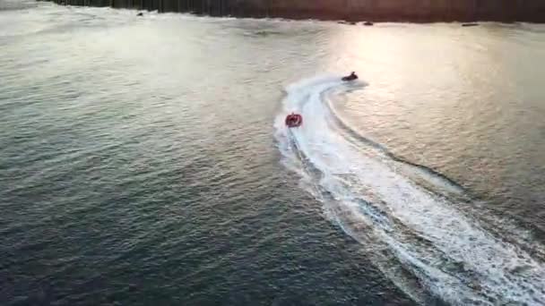 Jet Ski Puxando Uma Jangada Cheia Pessoas Durante Pôr Sol — Vídeo de Stock