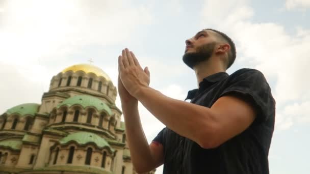 Ung Muslim Ber För Fred Framför Ett Kristet Tempel — Stockvideo