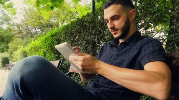 Joven Árabe Europeo Tocando Una Pantalla Tablet Parque — Vídeo de stock