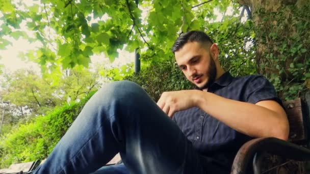 Joven Árabe Europeo Tocando Teléfono Inteligente Parque — Vídeo de stock