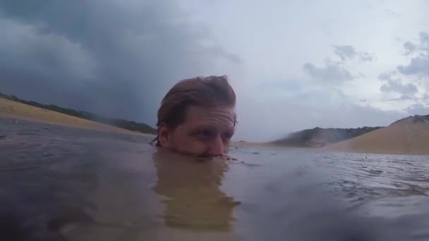 Man Dränkt Vatten Medan Storm Rullar Över Havet Och Regndroppar — Stockvideo