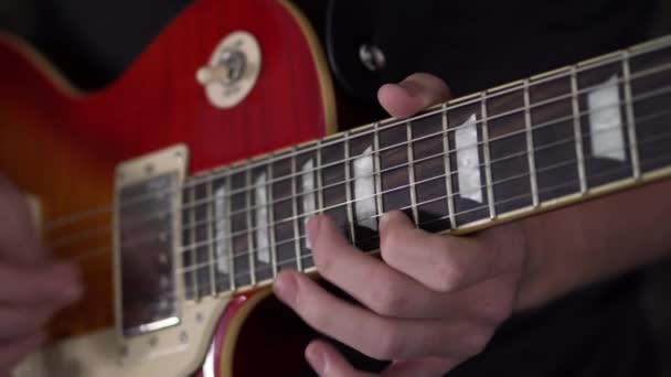 Les Paulスタイルのギターでソロを素早く選ぶ男のソロ モーション ショット — ストック動画