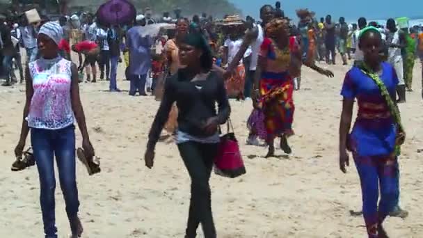 在科特迪瓦阿比让附近著名的大巴萨姆海滩上散步的科特迪瓦青年人数众多 — 图库视频影像