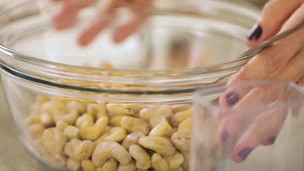 Vrouw Raakt Schaal Van Cashewnoten Met Vingers — Stockvideo