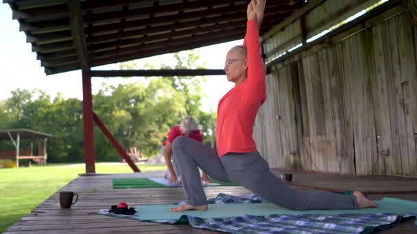 Två Mogna Kvinnor Som Gör Krigare Yoga Pose Och Sträcker — Stockvideo