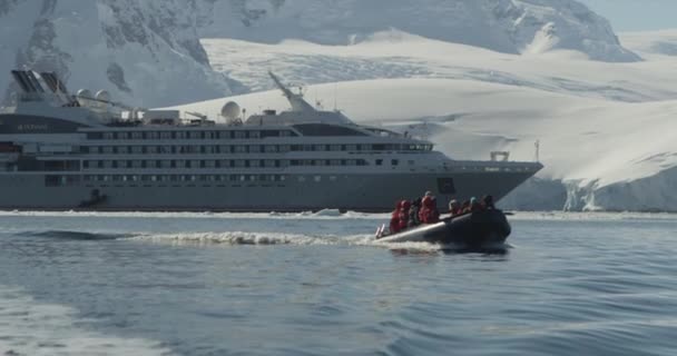 乗客とゾディアックは南極で氷山を探索するために船を出発します — ストック動画