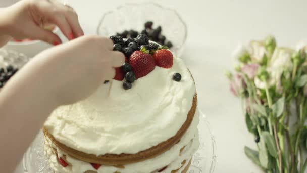 Vrouw Besprenkelt Bessen Bovenop Een Laagje Cake Een Lichte Keuken — Stockvideo