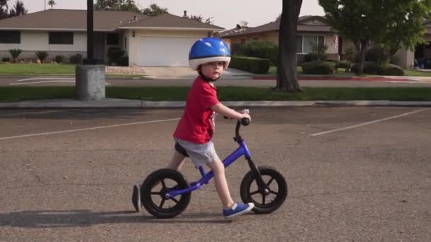 Scatto Rallentatore Ragazzo Che Cavalca Una Balance Bike Parcheggio Quartiere — Video Stock