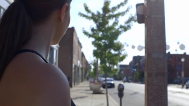 可爱的千禧年女孩回头望着城市街道上的相机 — 图库视频影像