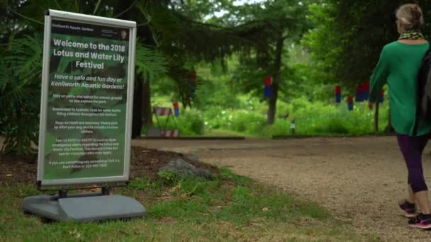 Ibu Dan Anak Berjalan Melewati Tanda Untuk Festival Lotus Kenilworth — Stok Video