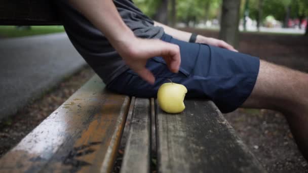 Человек Сидящий Скамейке Парке Берущий Немного Яблока — стоковое видео