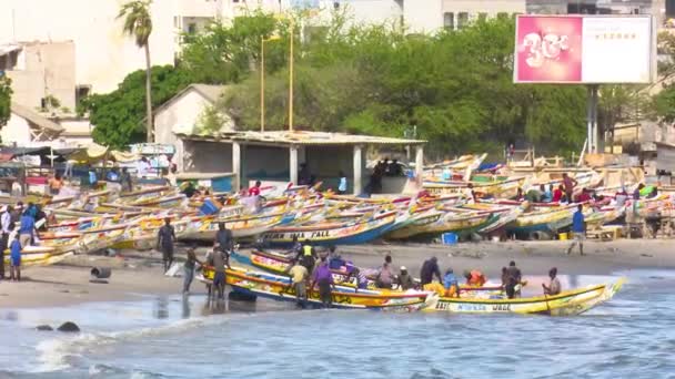 セネガルのダカールのスムベドウィン魚市場近くで船を準備するセネガルの伝統的な漁師 — ストック動画