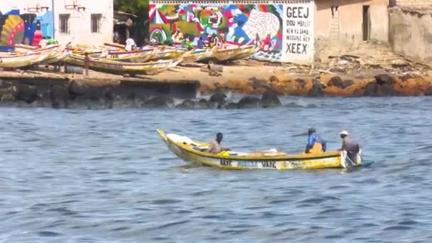 セネガルのダカールのスムベダイオーネ魚市場近くのボートに乗っている漁師 — ストック動画