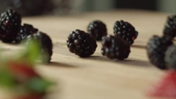 Nahaufnahme Von Brombeeren Die Auf Ein Holzschneidebrett Fallen Und Hüpfen — Stockvideo