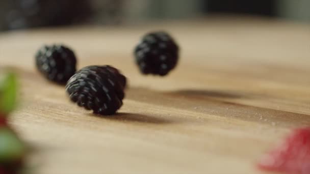 Nahaufnahme Von Brombeeren Die Auf Einem Holzschneidebrett Hüpfen — Stockvideo