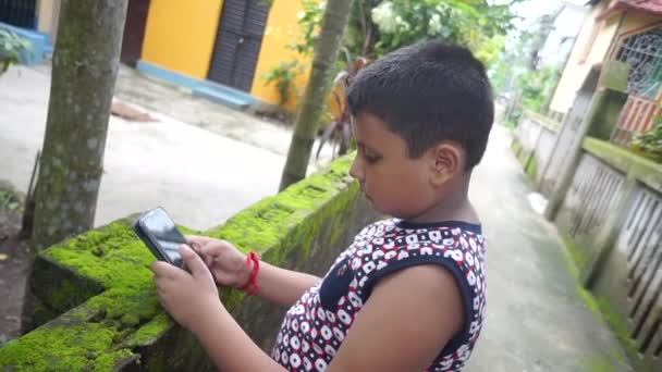 Ένα Μικρό Ασιατικό Αγόρι Χρησιμοποιεί Smartphone Του Παίζει Παιχνίδια Στο — Αρχείο Βίντεο