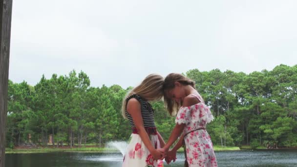 Zwei junge beste Freundinnen verbringen gemeinsam Zeit im Freien in der Natur. Hände halten, Köpfe neigen und Herzform formen.