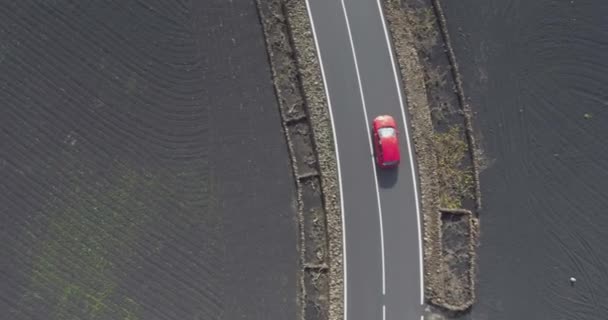 Czerwony Samochód Jest Śledzony Abve Przez Drona Czarnej Scenerii Wulkanicznej — Wideo stockowe