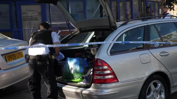 イギリス ロンドン 2018年6月 ロンドン警察官は慎重に午後に証拠のために車のトランクを検索します — ストック動画