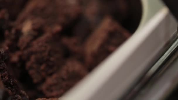 スプーンチョコレートブラウニーの片をすくい取る 冷凍ヨーグルト アイスクリームのトッピング スライダーショット マクロだ 極端なクローズアップ — ストック動画