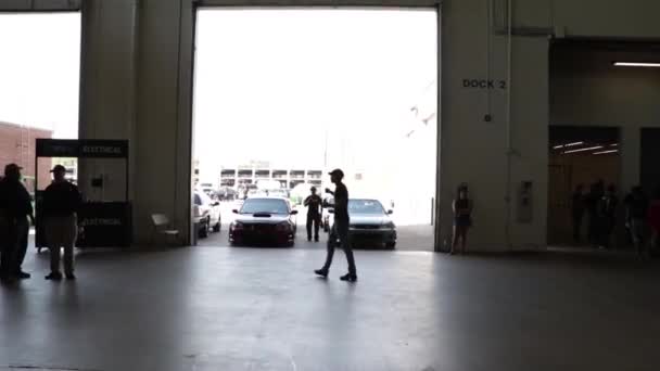 Człowiek Sylwetka Spaceruje Przed Samochodami Pokazie Samochodów — Wideo stockowe