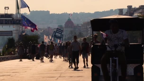 人々はプロムナード アングライス ニース フランス 2018年8月に歩いています 2016年のテロ事件の現場 ネグレスコホテルに面した 自転車タクシーが通り過ぎる — ストック動画
