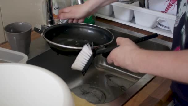 Eine Pfanne Der Spüle Mit Wasser Und Spülmittel Spülen Gibt — Stockvideo