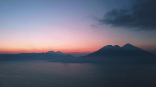 グアテマラでの紫色の日没の間のアッティラン湖を横断する火山 — ストック動画