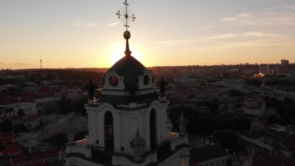 在欧洲立陶宛维尔纽斯的圣约翰教堂的钟塔周围 有人在飞来飞去 阳光透过屋顶射出光芒 背景中的老城区 — 图库视频影像