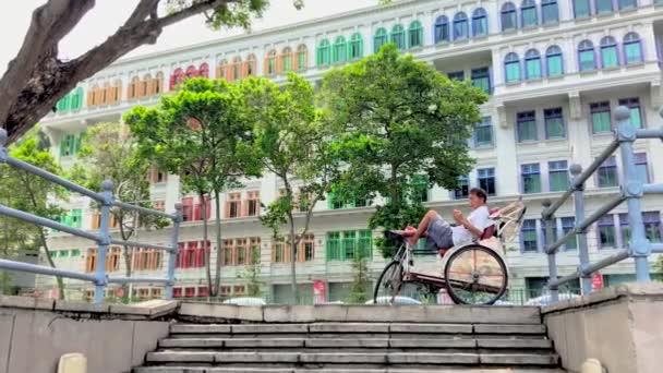 新加坡旧山街警署大楼前 一个人在树下休息 — 图库视频影像