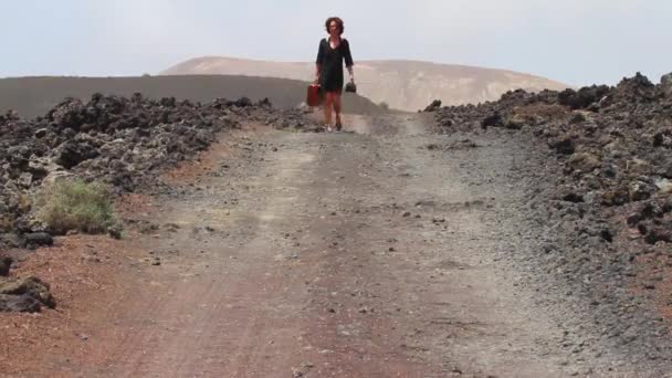 Жінка Старовинною Подорожньою Валіза Йде Прямою Вулканічною Дорогою Вулканом Задньому — стокове відео