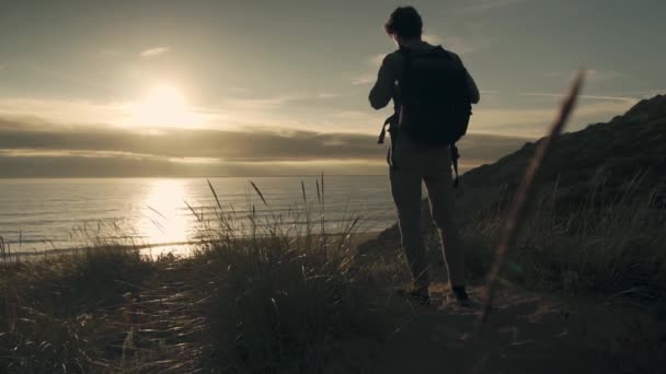 Orang Dengan Ransel Berjalan Menuju Matahari Terbenam Atas Laut Pergerakan — Stok Video