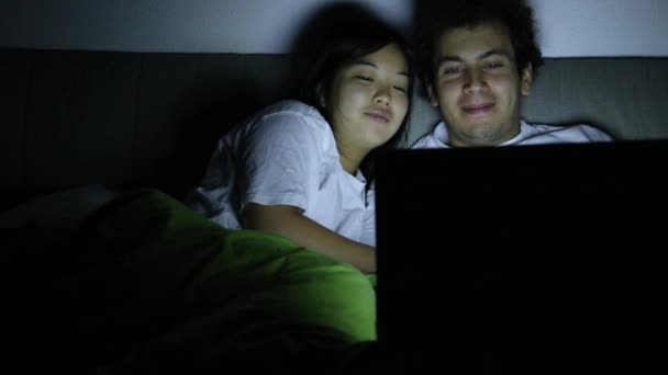 Ένα Ζευγάρι Στο Κρεβάτι Βράδυ Κοιτάζοντας Ένα Φορητό Υπολογιστή — Αρχείο Βίντεο
